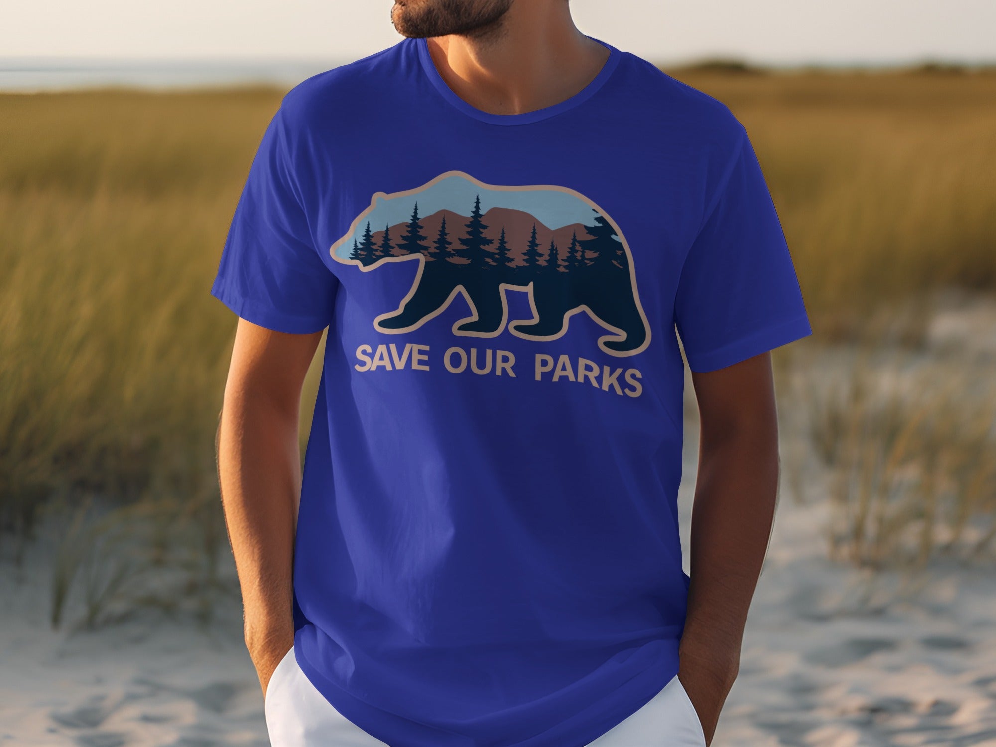 Blue t-shirt with a bear silhouette filled with a forest and mountains illustration, text reads "SAVE OUR PARKS".