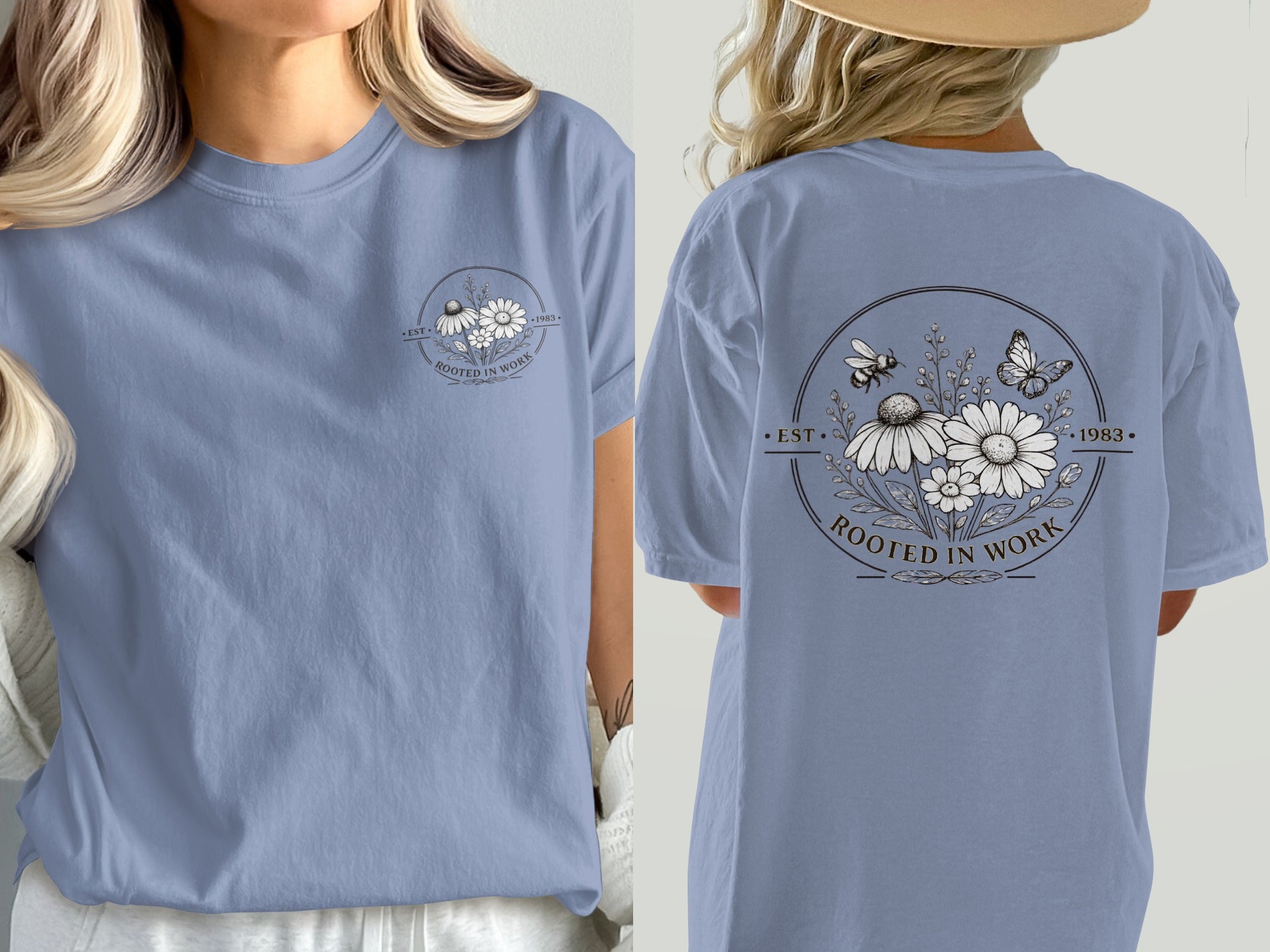 Blue t-shirt featuring a circular graphic with flowers, bees, a butterfly, and text "ROOTED IN WORK EST 1983".