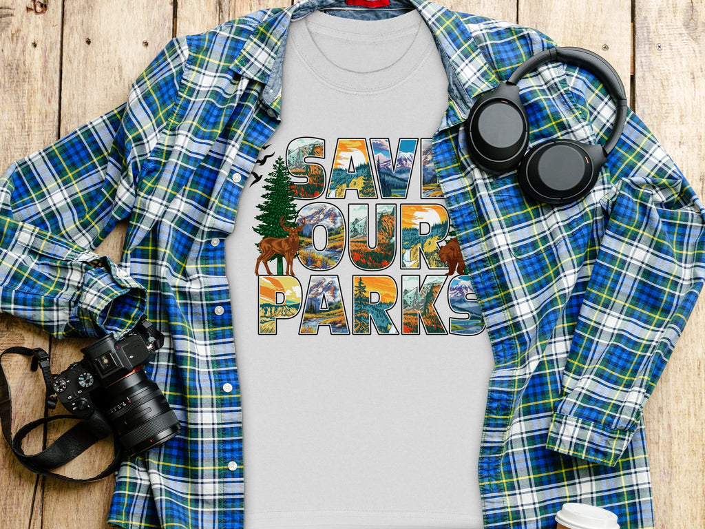 White t-shirt with "SAVE OUR PARKS" text, featuring nature scenes.