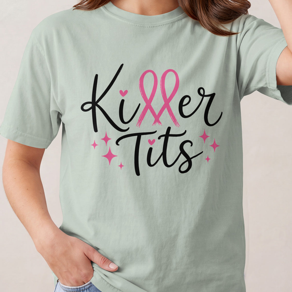 Light green t-shirt with black text "Killer Tits" and pink breast cancer ribbons.