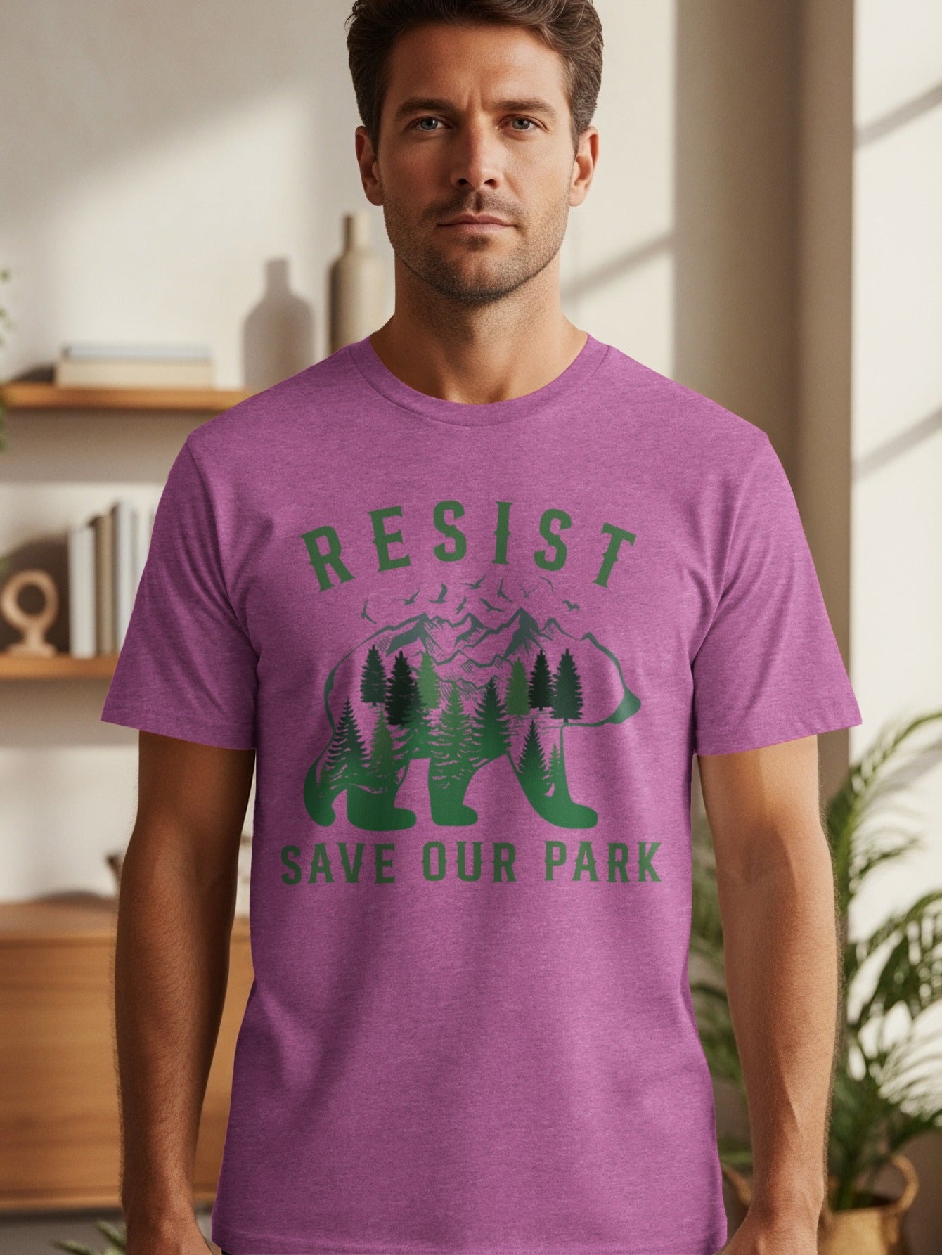 Purple t-shirt with green text and bear silhouette filled with trees and mountains.
