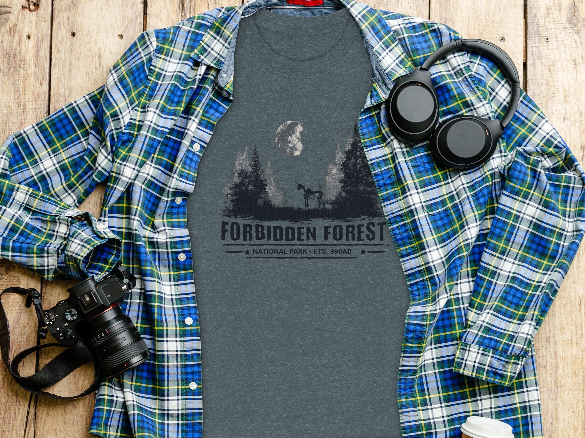 T-shirt with "FORBIDDEN FOREST NATIONAL PARK" graphic, laid on a flannel shirt.
