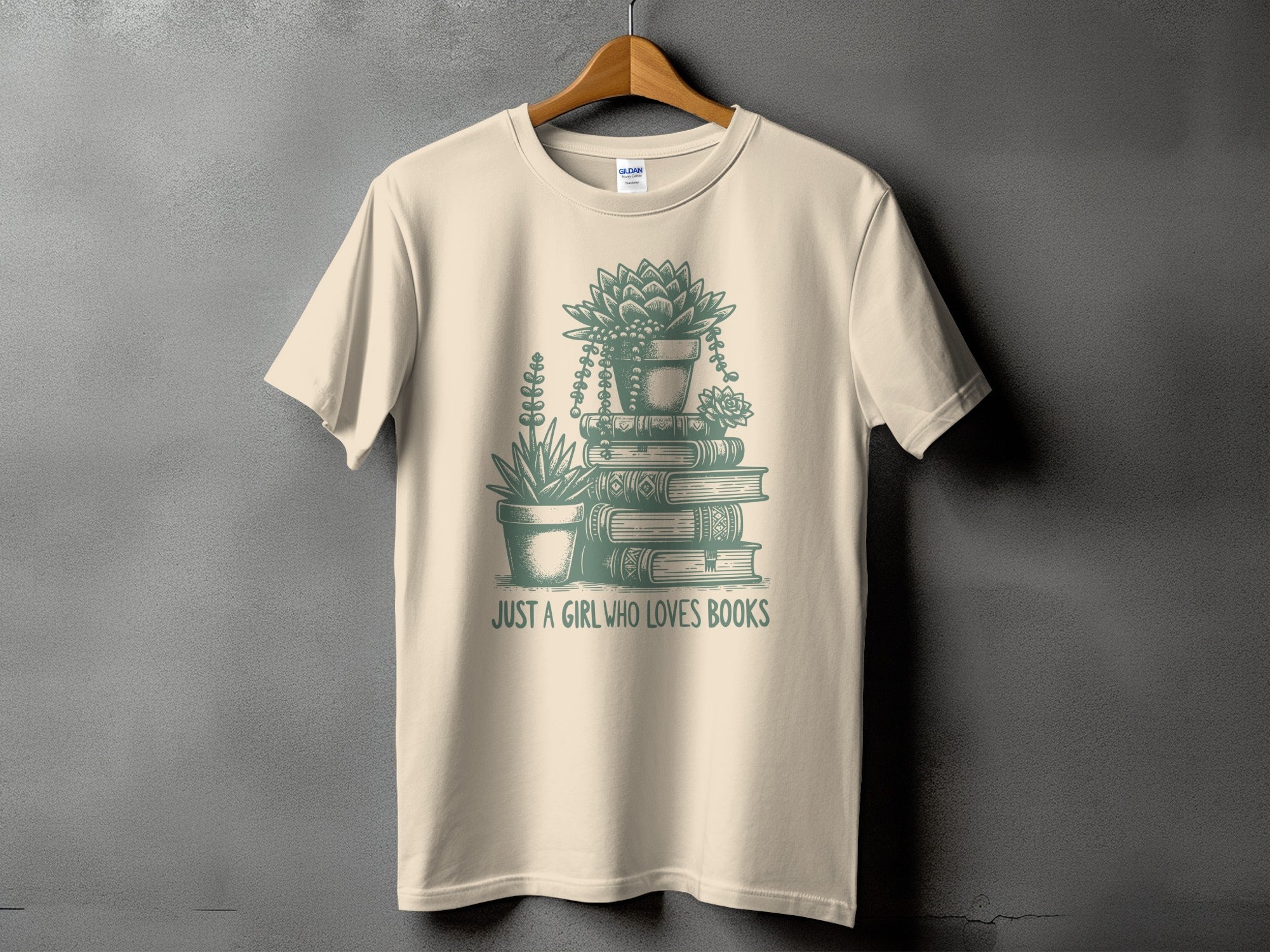 Cream t-shirt with illustration of stacked books and plants, text "JUST A GIRL WHO LOVES BOOKS".