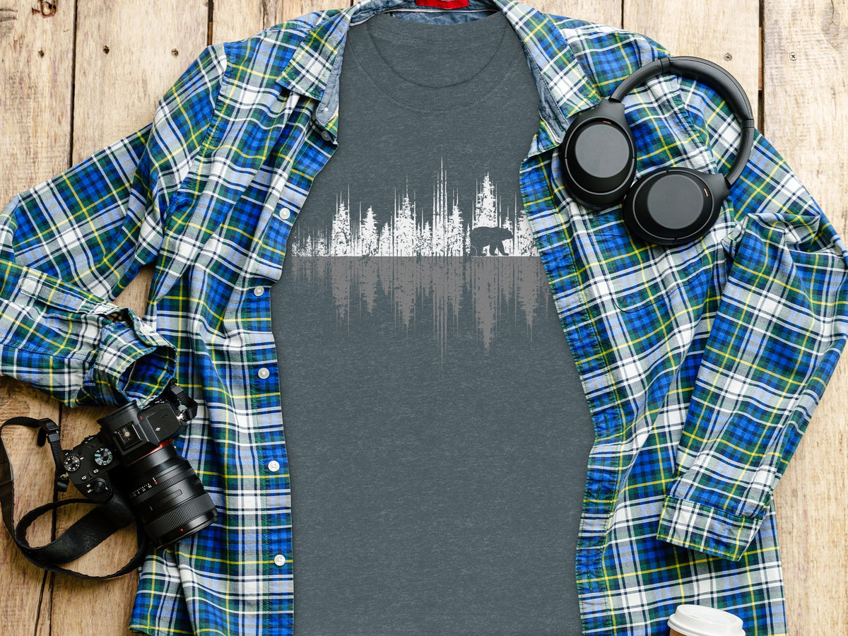 Gray t-shirt with white forest and bear graphic, layered under plaid shirt.