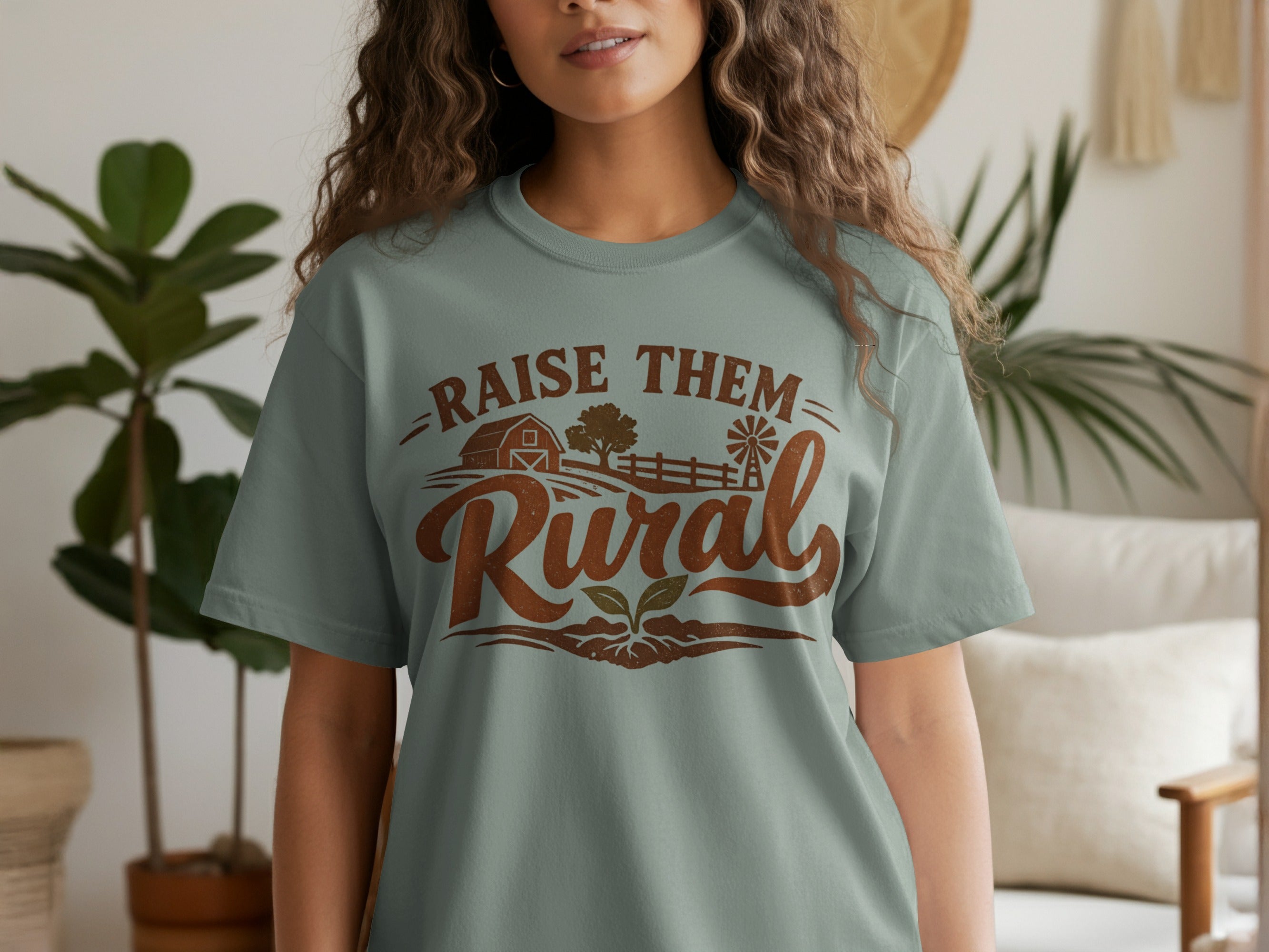 Light blue t-shirt with "Raise Them Rural" text and farm graphics.