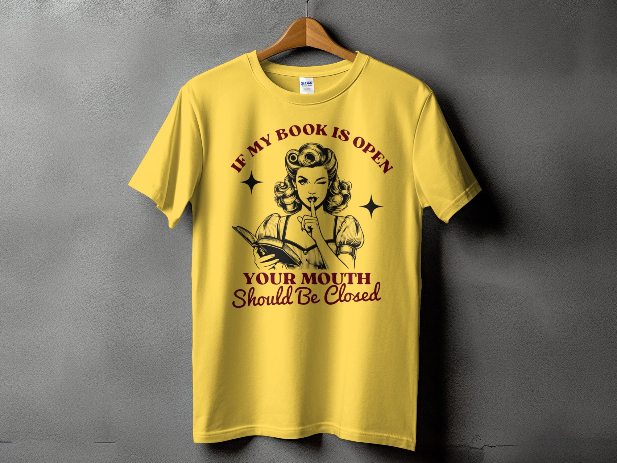 Yellow t-shirt with retro woman reading and text "If my book is open your mouth should be closed."