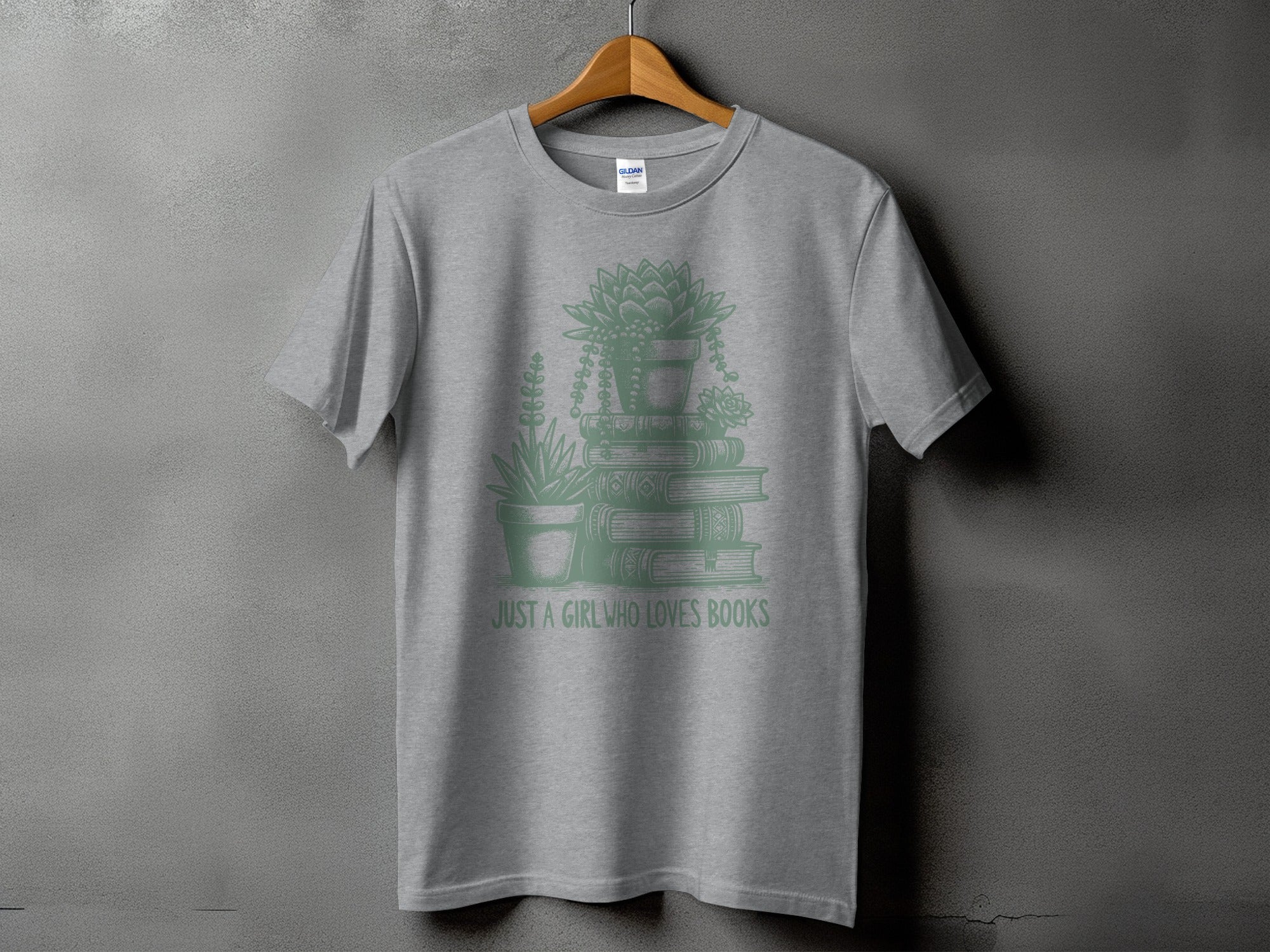 Grey t-shirt with stacked books, potted plants, and "JUST A GIRL WHO LOVES BOOKS" text.