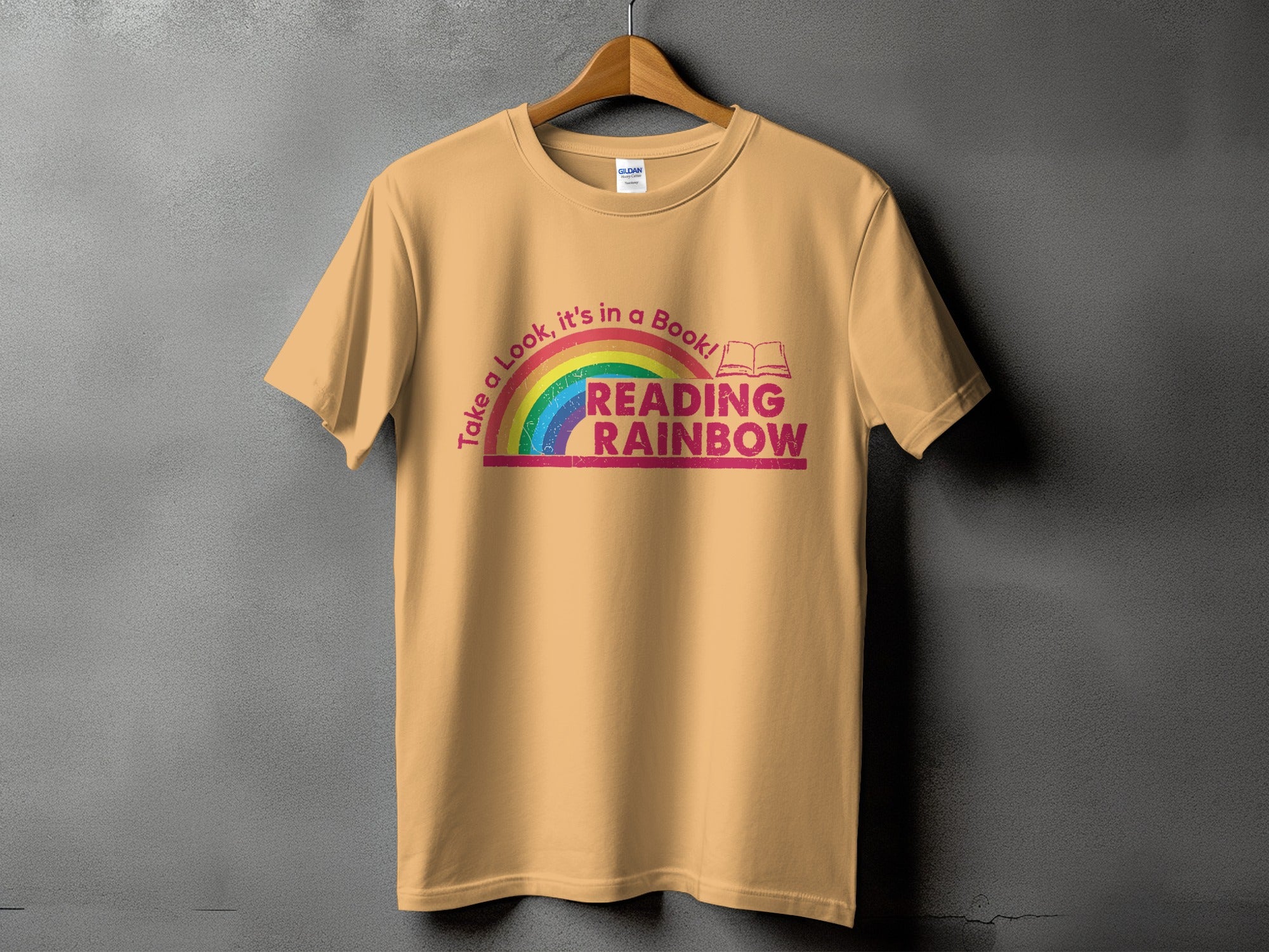 Light peach t-shirt with "Take a Look, it's in a Book! READING RAINBOW" text and rainbow graphic.