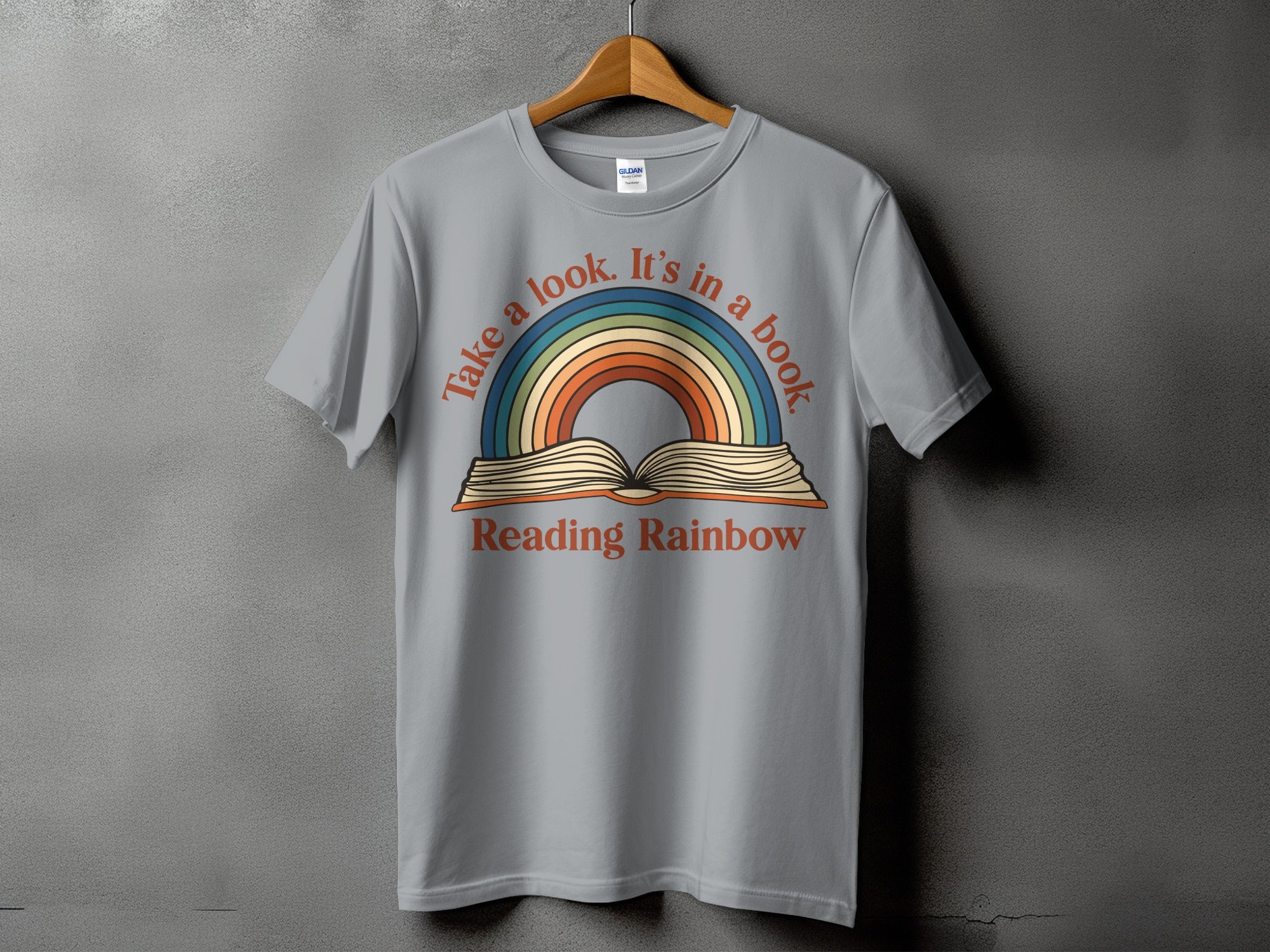 Grey t-shirt with "Take a look. It's in a book Reading Rainbow" text and rainbow graphic.