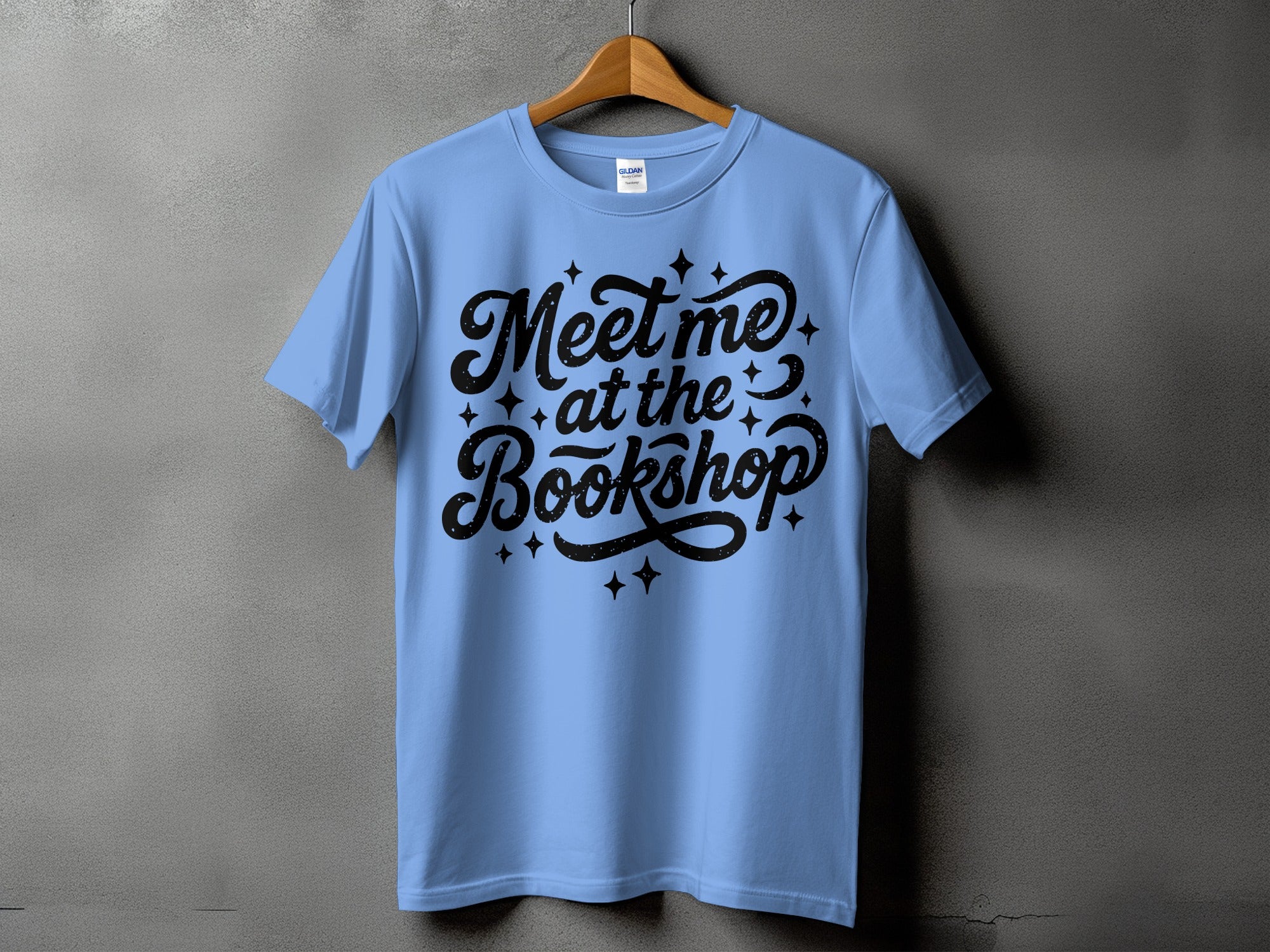 Light blue t-shirt with black text that says "Meet me at the Bookshop."