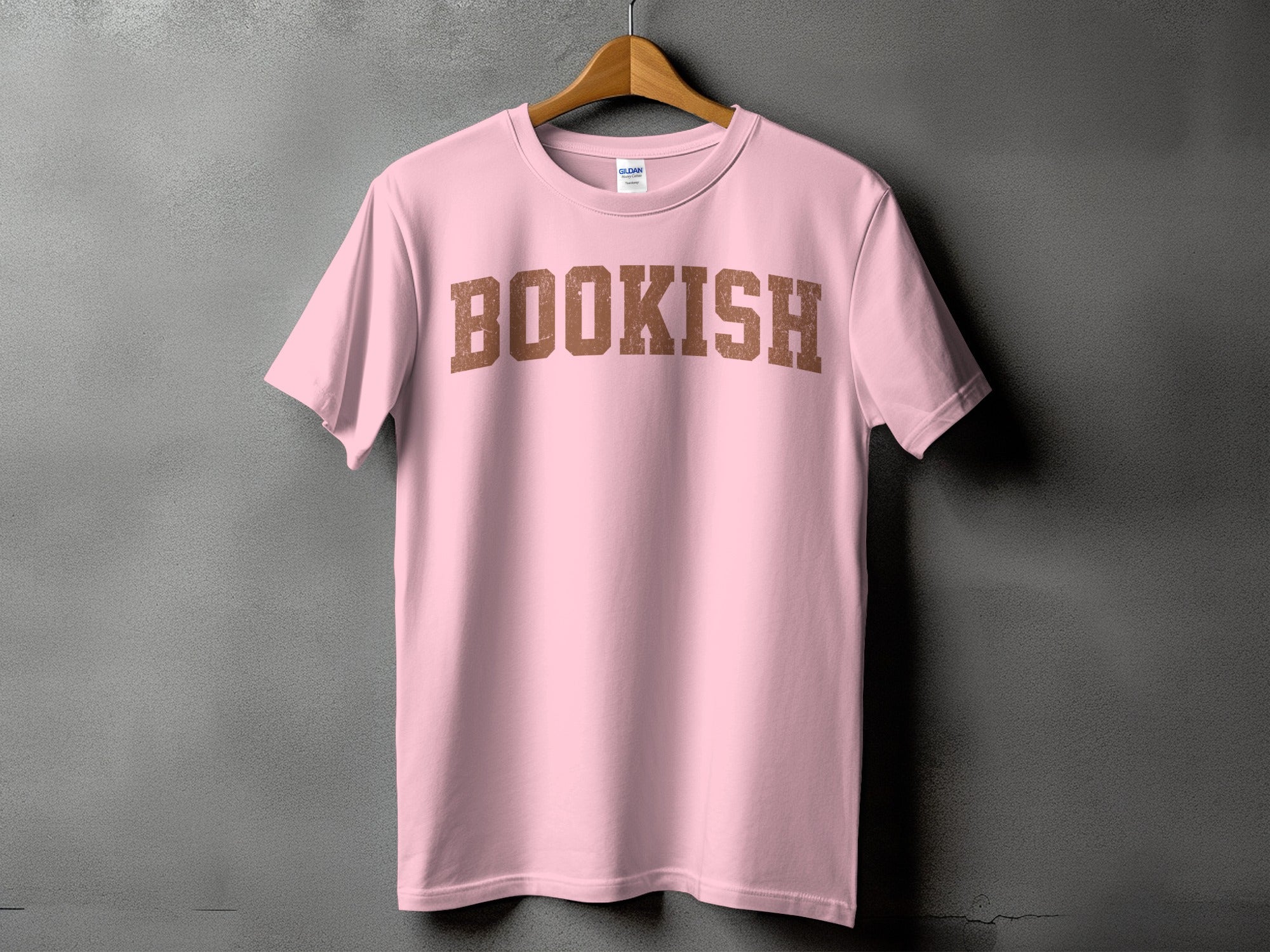 Pink t-shirt with "BOOKISH" printed in distressed brown collegiate font.
