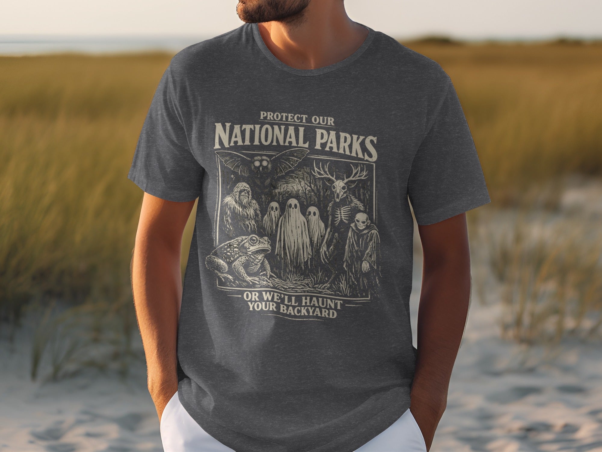 Graphic tee with "Protect Our National Parks" and spooky creatures, "Or We'll Haunt Your Backyard."