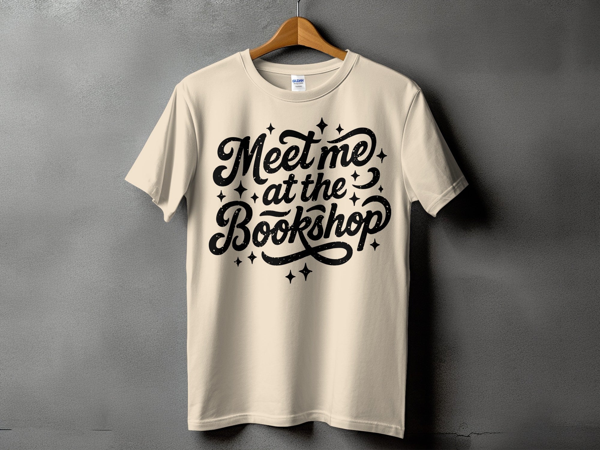 Cream Gildan t-shirt with black text "Meet me at the Bookshop" and stars.