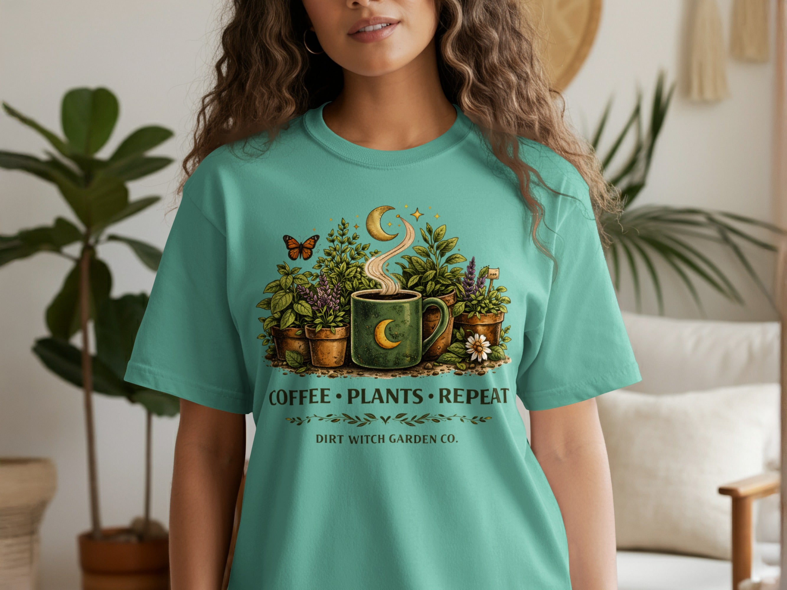 Teal shirt graphic with coffee, plants, moon, crescent, stars, and text: Coffee Plants Repeat Dirt Witch Garden Co.