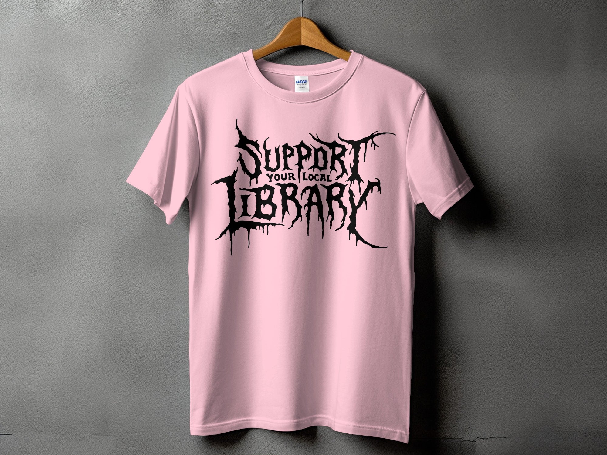 Pink t-shirt with black gothic lettering that reads "SUPPORT YOUR LOCAL LIBRARY".