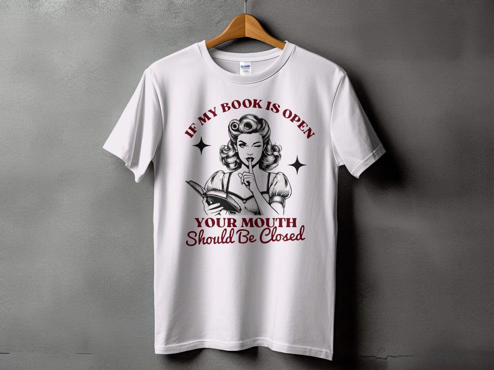 White t-shirt with retro illustration and text "If my book is open, your mouth should be closed".