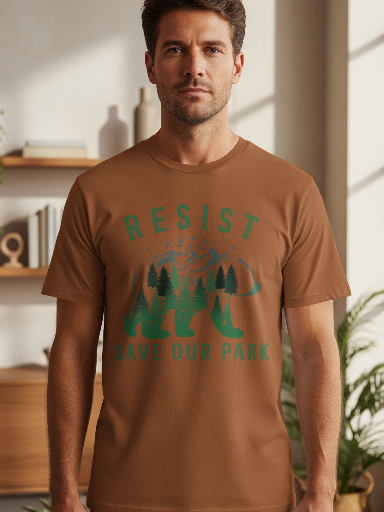 Brown t-shirt featuring a bear silhouette filled with trees and mountains, text reads "RESIST SAVE OUR PARK".