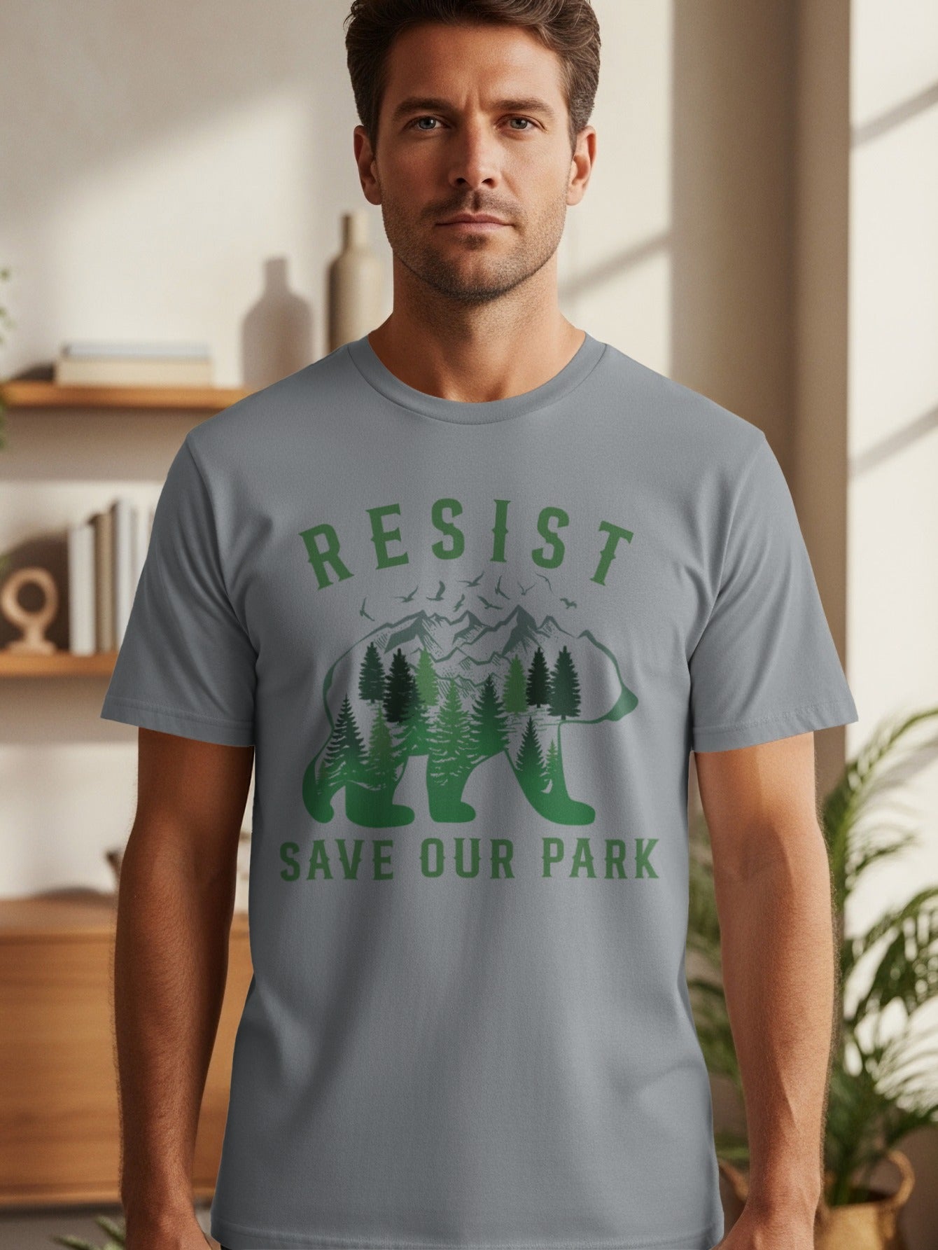 Man wearing grey t-shirt with "RESIST SAVE OUR PARK" and bear forest graphic.