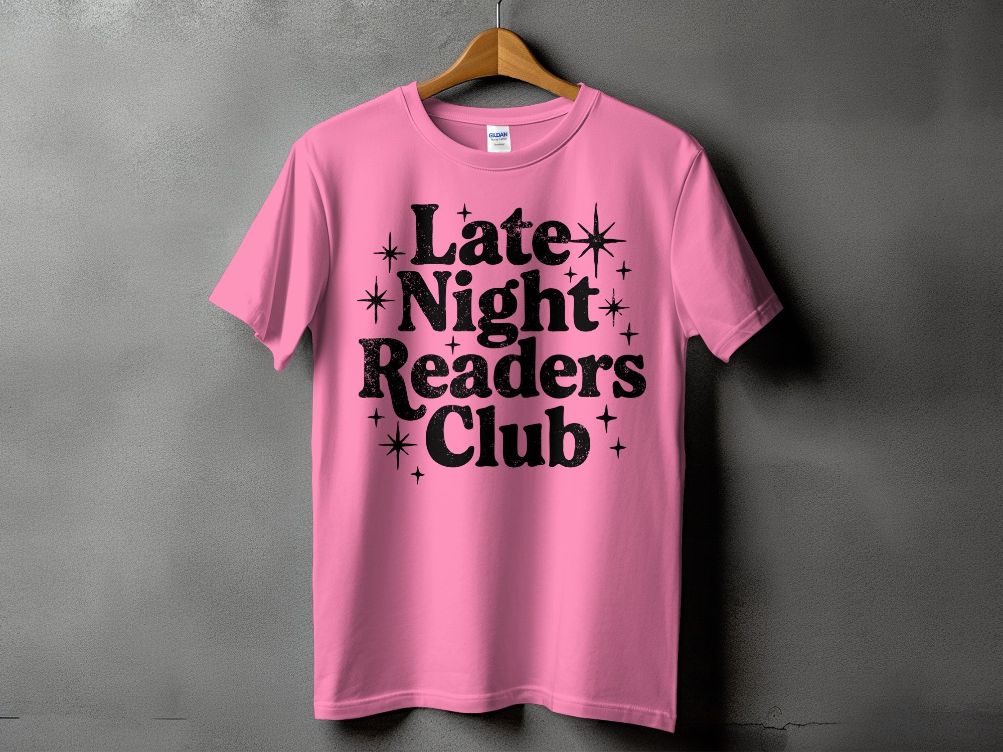Pink t-shirt with black text "Late Night Readers Club" and stars.