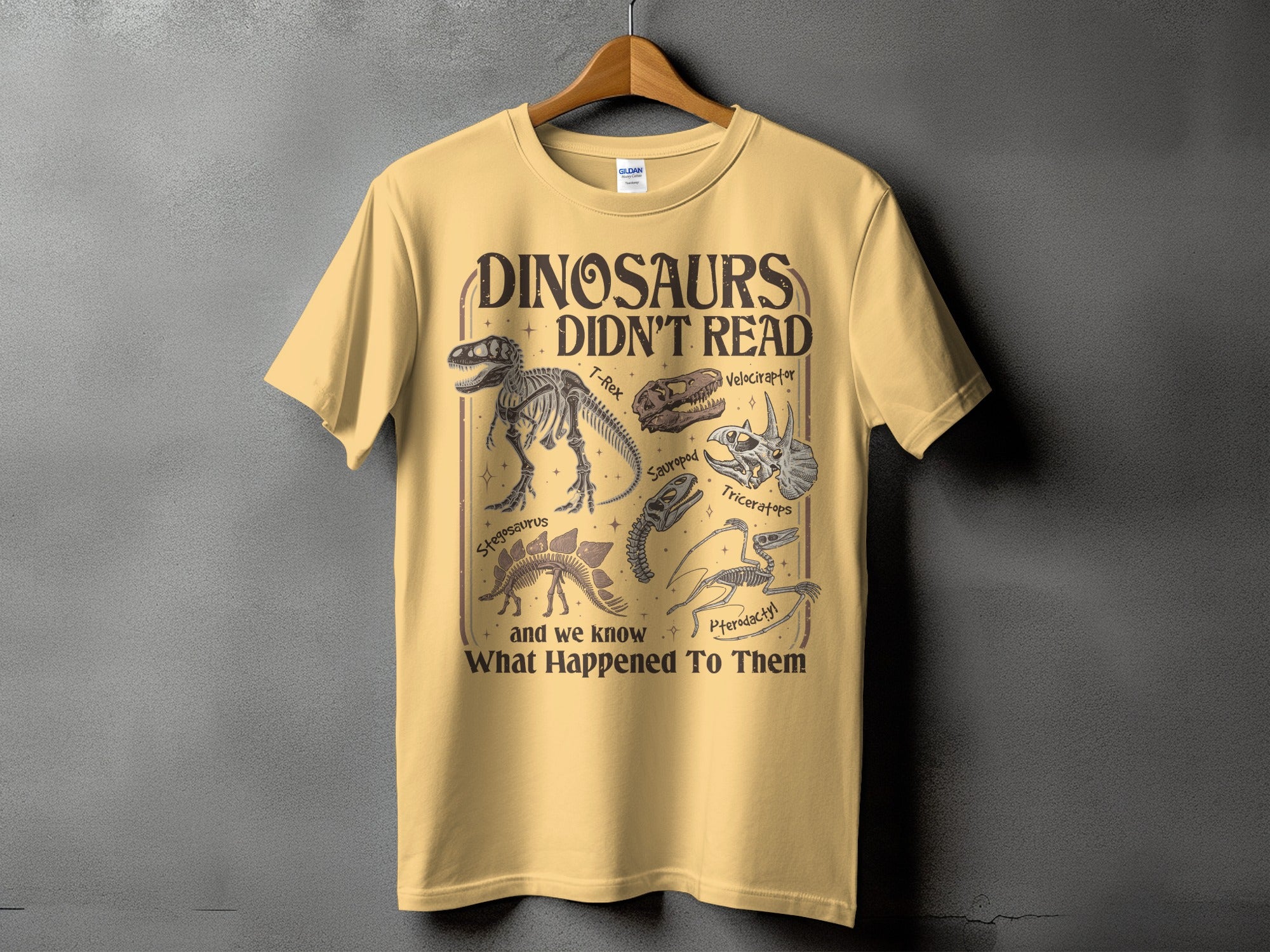 Yellow t-shirt with "Dinosaurs Didn't Read" text and dinosaur skeleton illustrations.