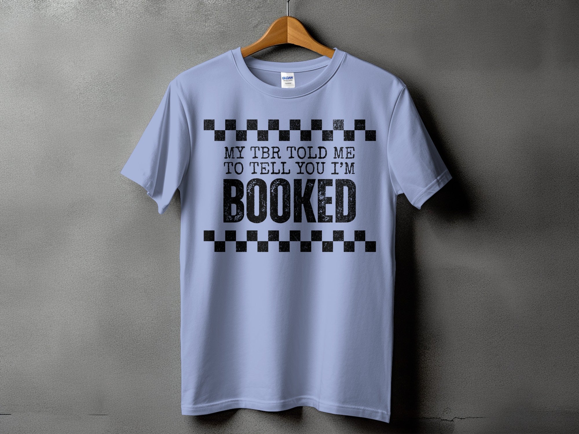 Light blue t-shirt with black text reading "MY TBR TOLD ME TO TELL YOU I'M BOOKED"
