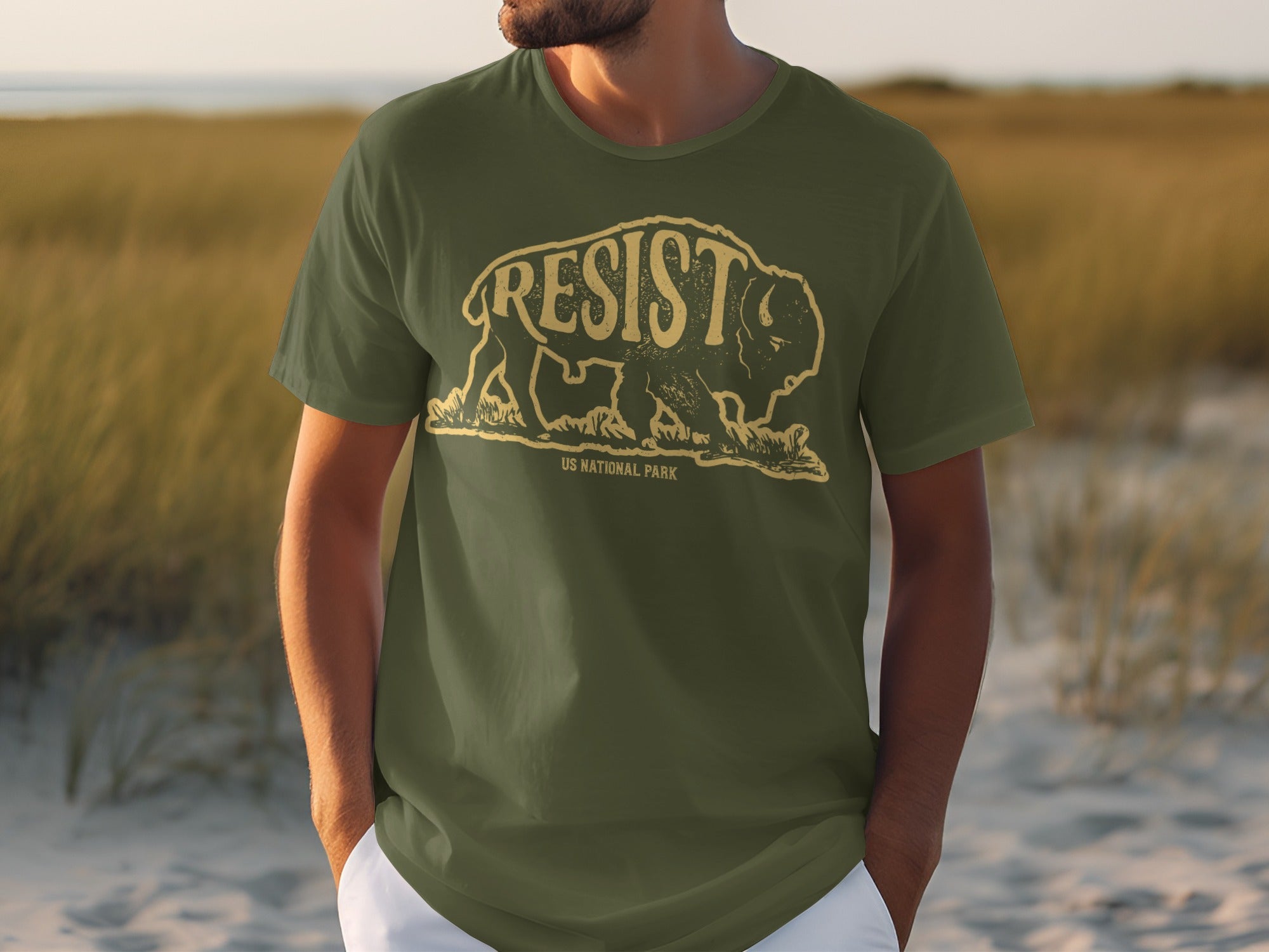 Olive t-shirt with distressed bison graphic and "RESIST US NATIONAL PARK" text.
