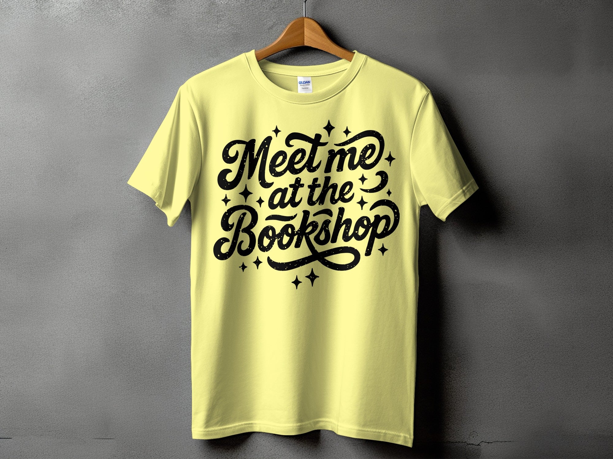 Yellow t-shirt with black "Meet me at the Bookshop" text and stars.