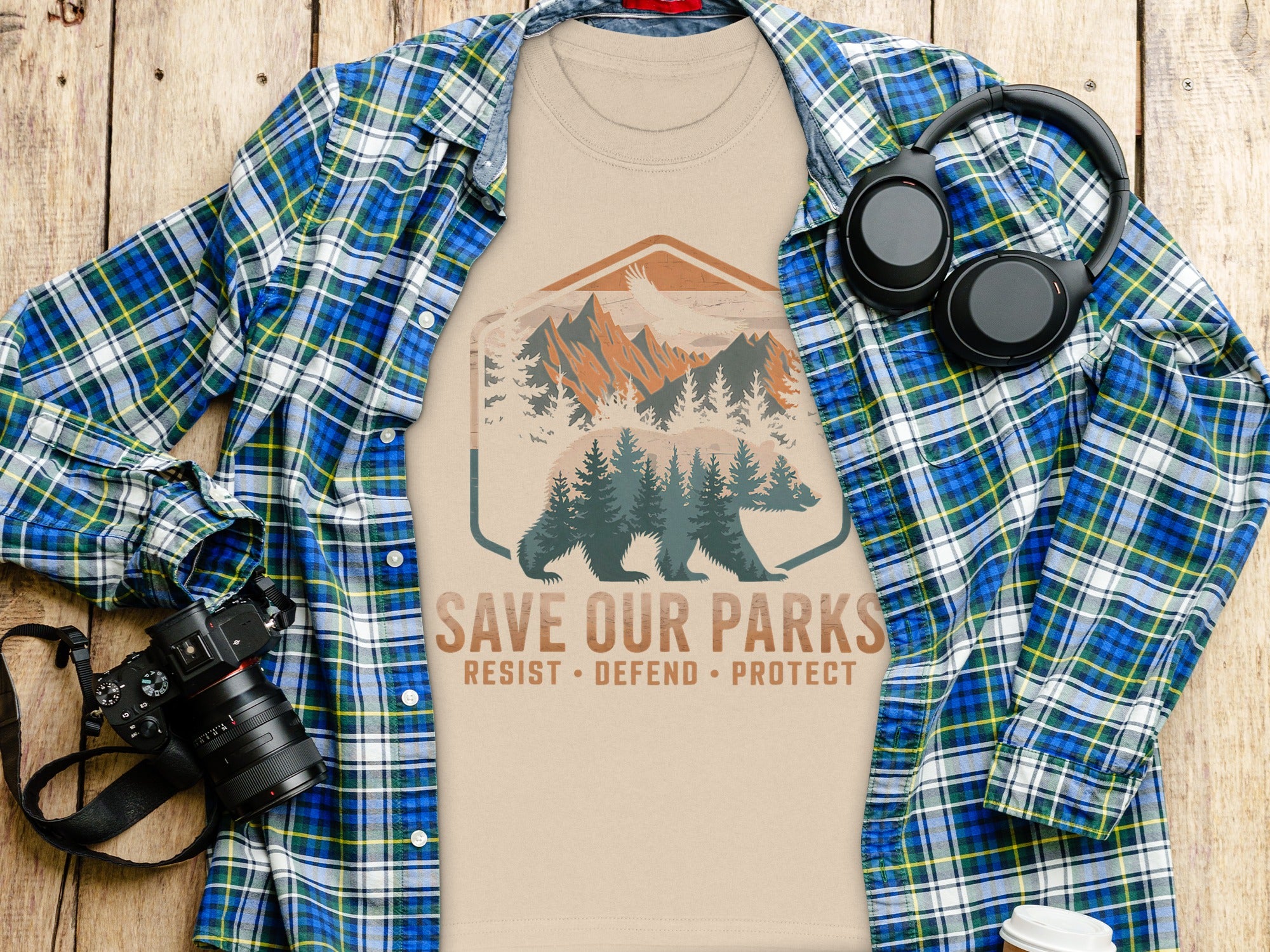 T-shirt with "Save Our Parks" text and bear graphic, draped over a flannel shirt.