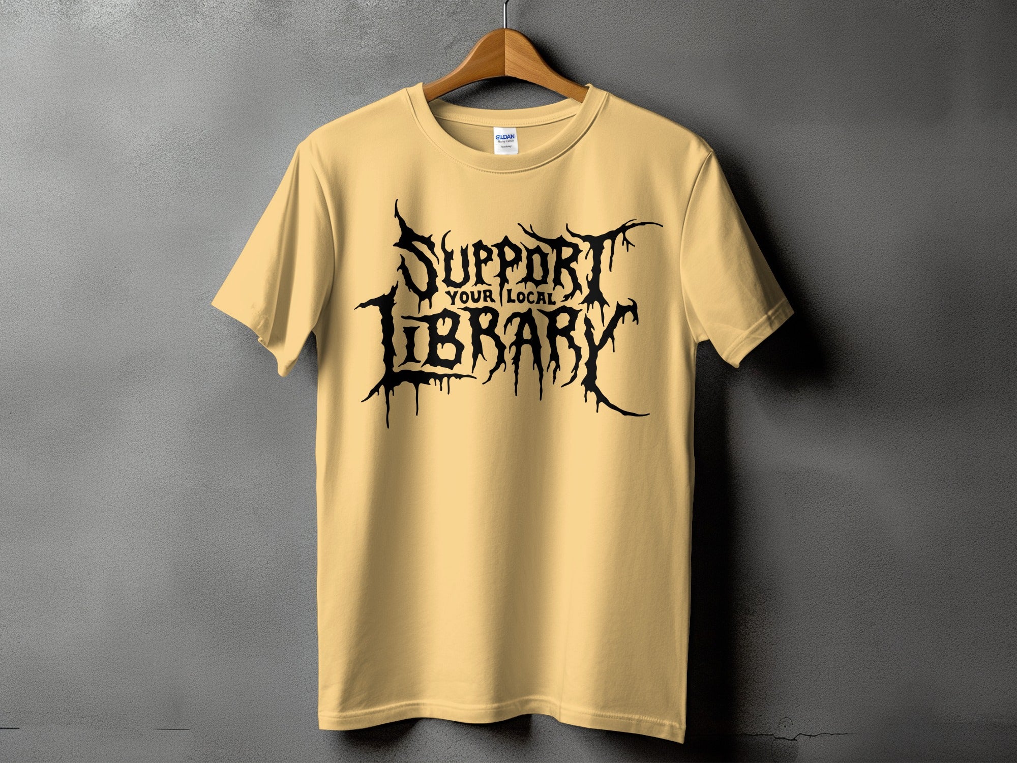 Light yellow t-shirt with black gothic text reading "SUPPORT YOUR LOCAL LIBRARY".
