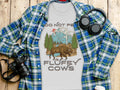 White t-shirt with text "DO NOT PE" and bison in mountain landscape, "THE FLUFFY COWS"
