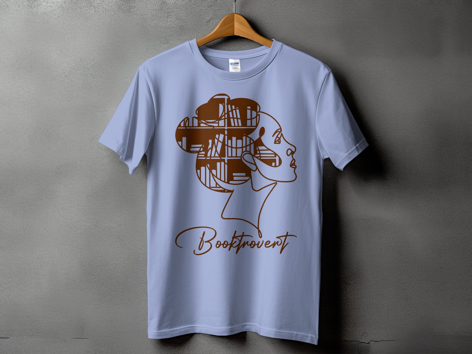 Light blue t-shirt with brown line art of a woman's profile and bookshelves.
