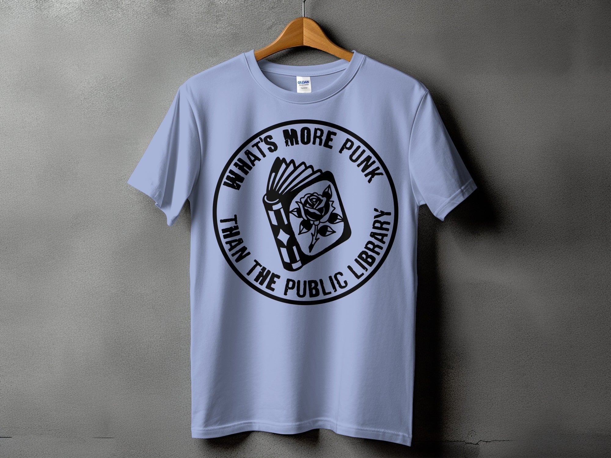 Light blue t-shirt with black graphic of an open book and rose, text reads "What's More Punk Than The Public Library".
