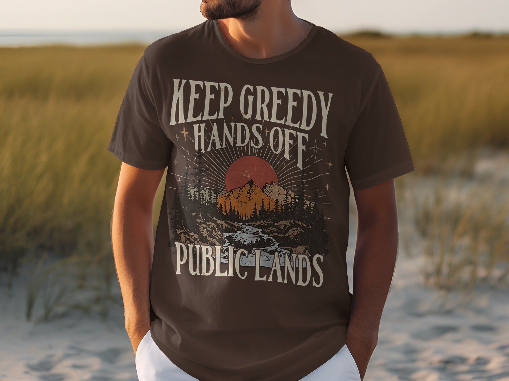 Brown t-shirt with "Keep Greedy Hands Off Public Lands" and mountain scene design.