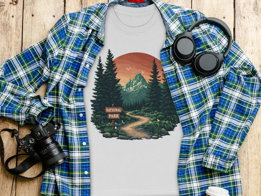 T-shirt with national park graphic, plaid shirt, camera, and headphones.