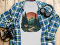 T-shirt with national park graphic, plaid shirt, camera, and headphones.