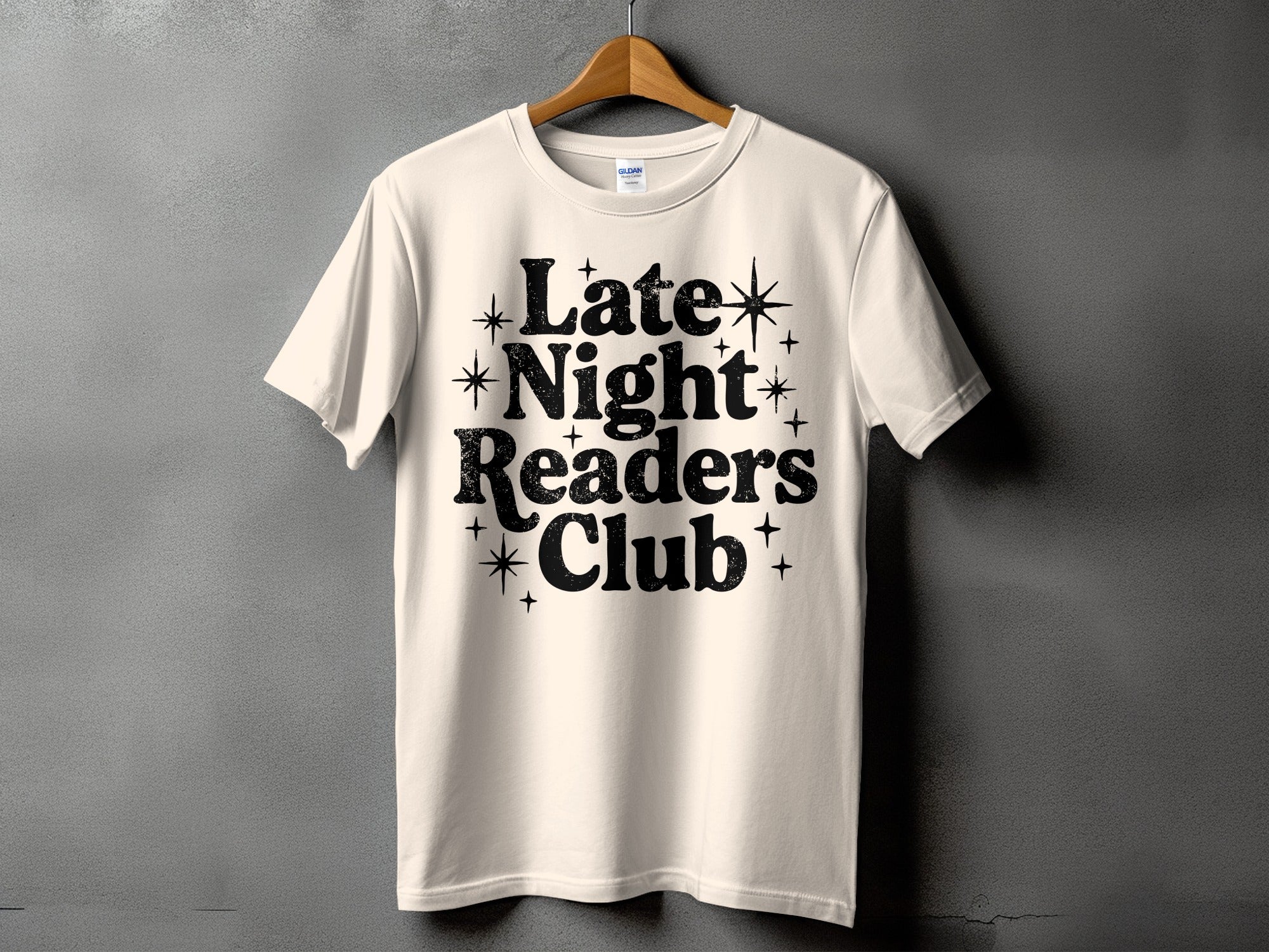 Cream t-shirt with black text "Late Night Readers Club" and stars.