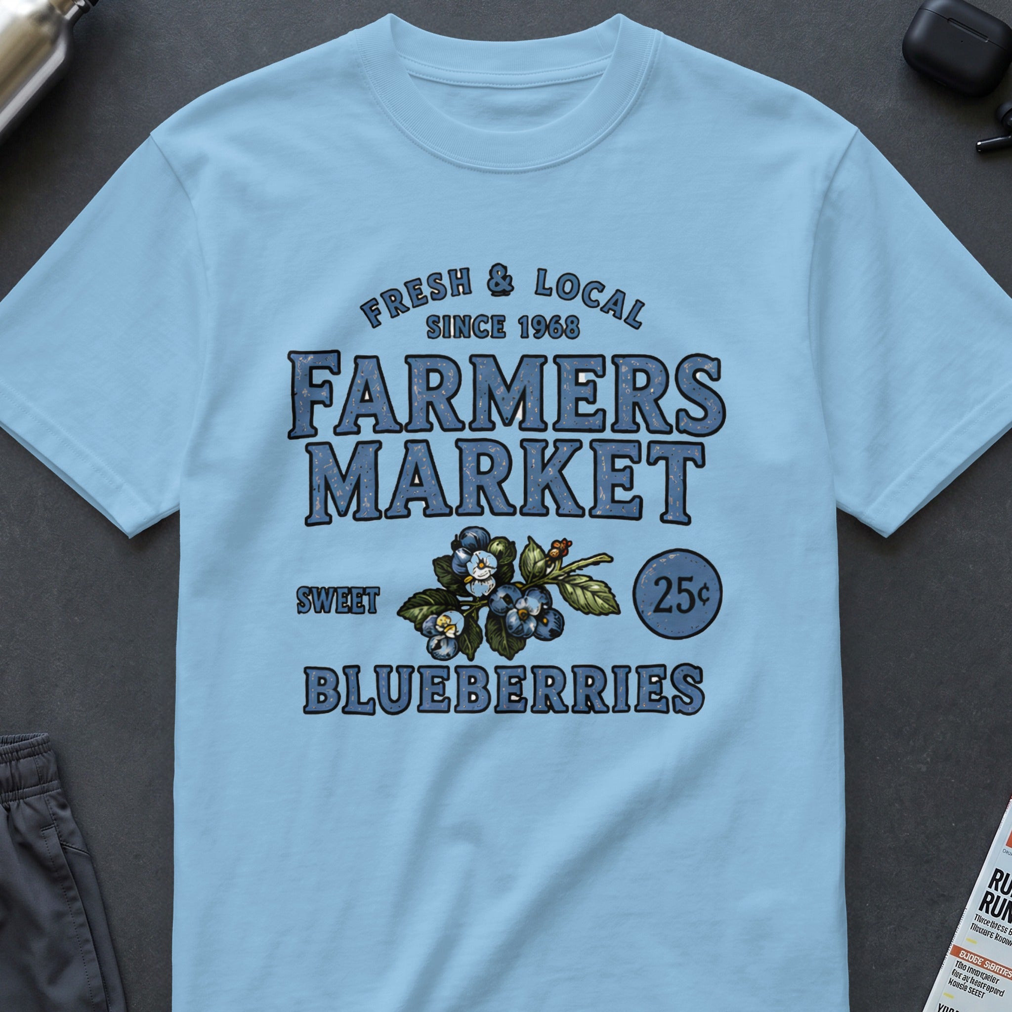 Light blue t-shirt with "Farmers Market Sweet Blueberries" graphic and blueberries illustration.