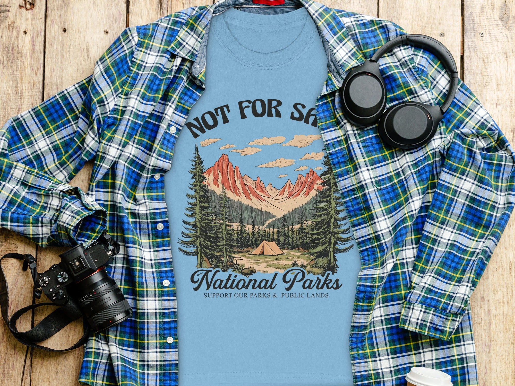 Light blue t-shirt with "National Parks" camping graphic and supporting text.