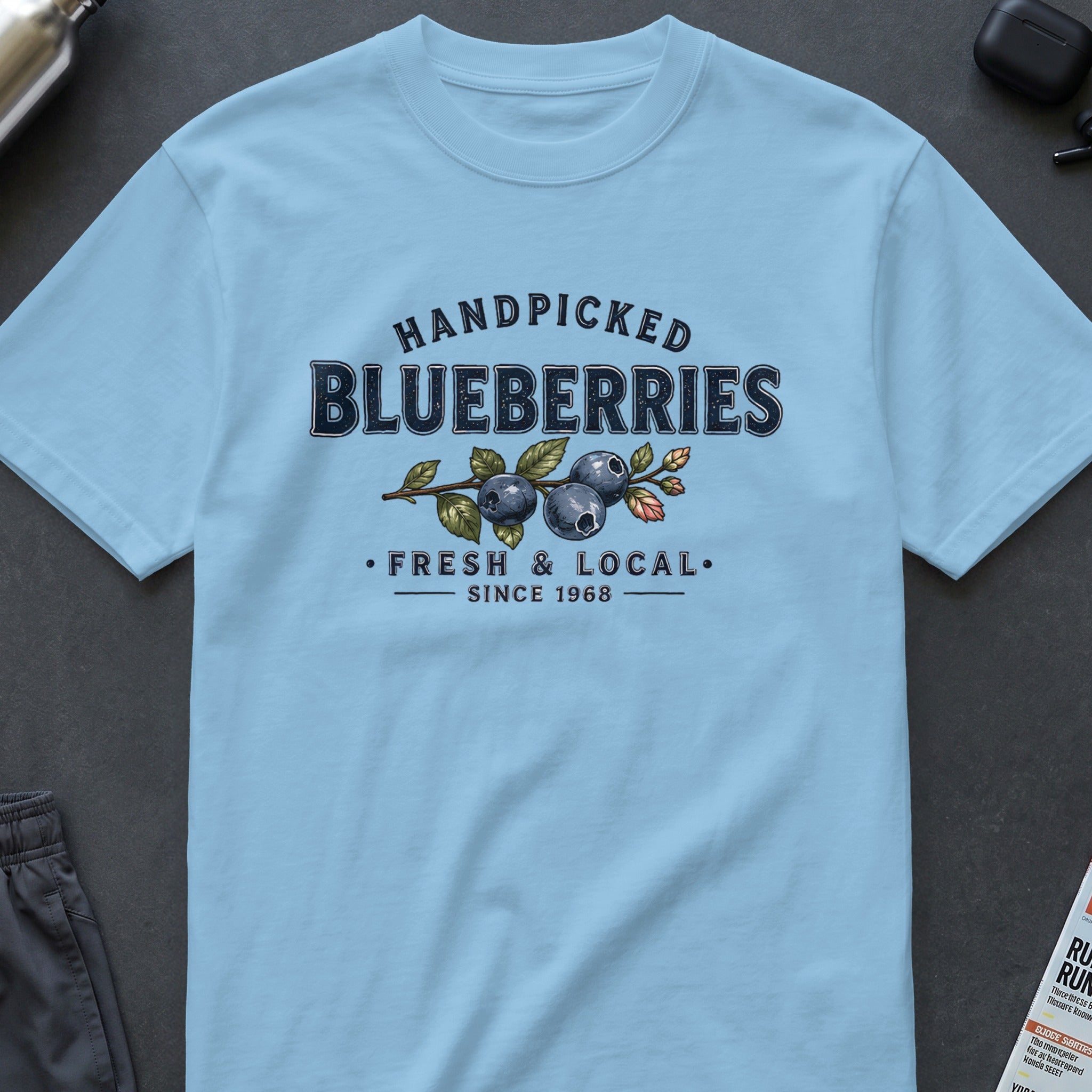 Light blue t-shirt with "Handpicked Blueberries Fresh & Local Since 1968" graphic.