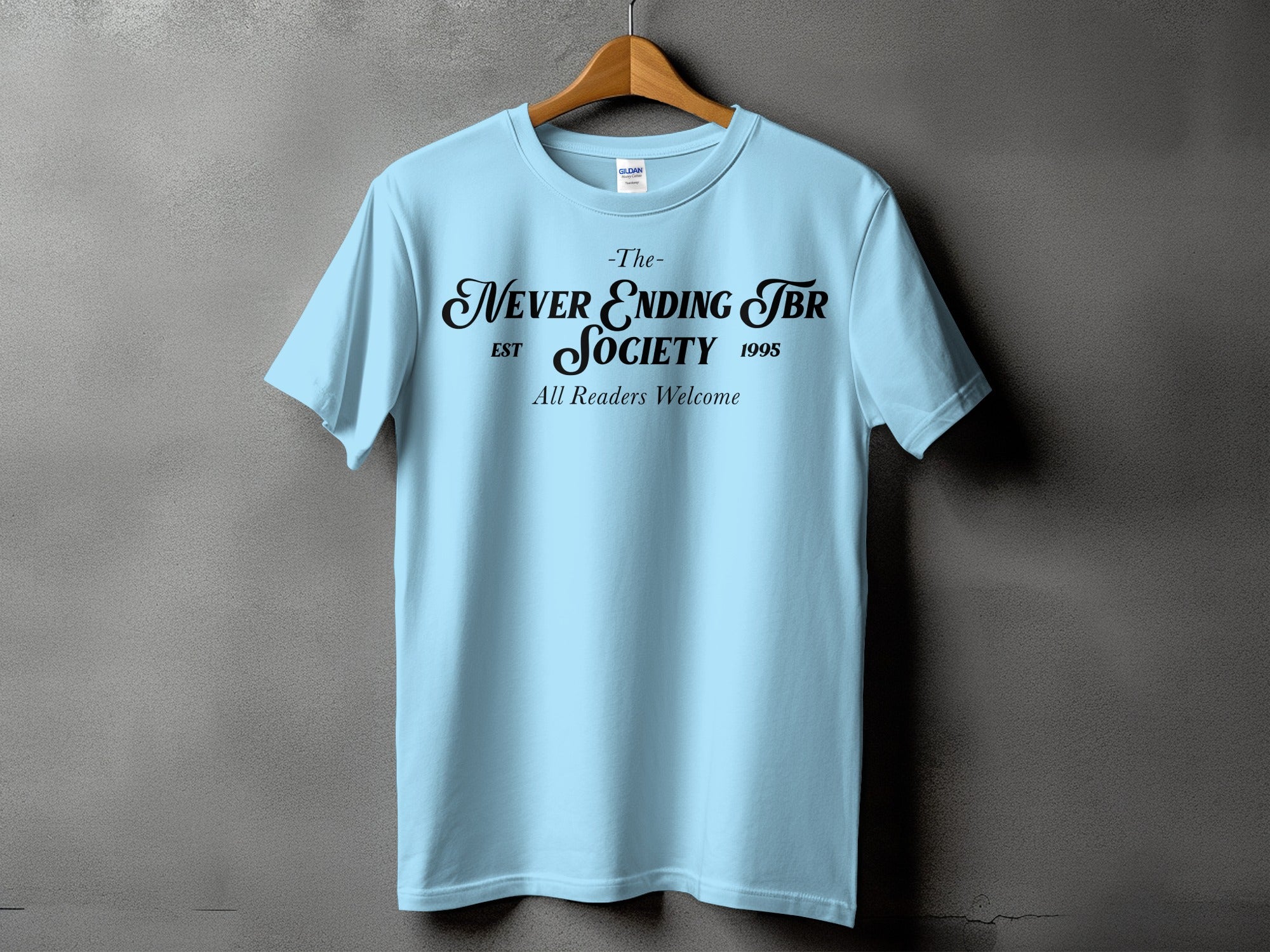 Light blue t-shirt with black text: "The- Never Ending TBR SOCIETY EST 1995 All Readers Welcome"