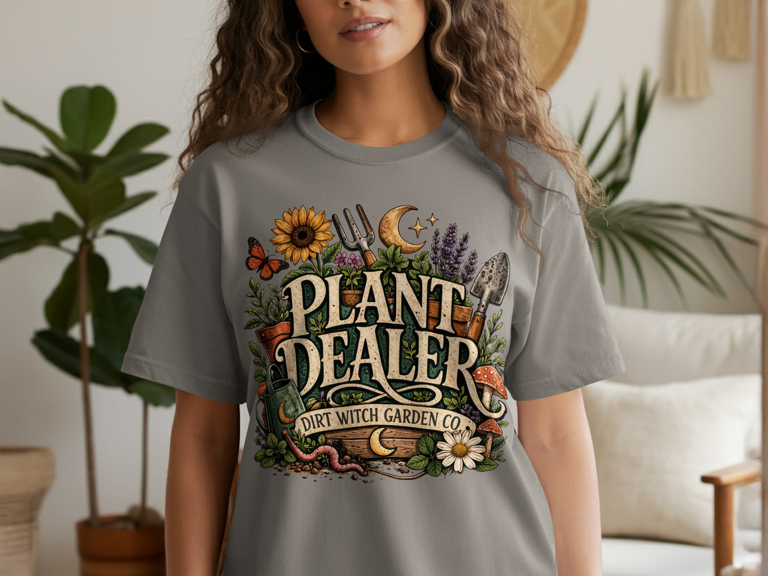 "Plant Dealer Dirt Witch Garden Co." text on a gray t-shirt with gardening motif.