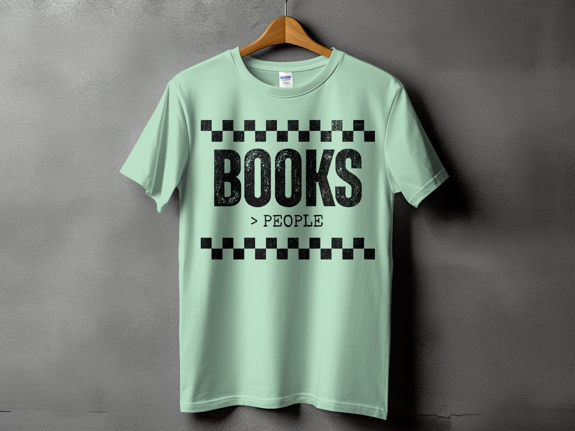 Light mint green t-shirt displays "BOOKS > PEOPLE" in distressed black text.