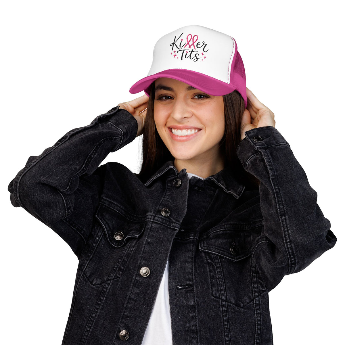 Woman wearing pink and white trucker hat with "Killer Tits" text and pink ribbon.