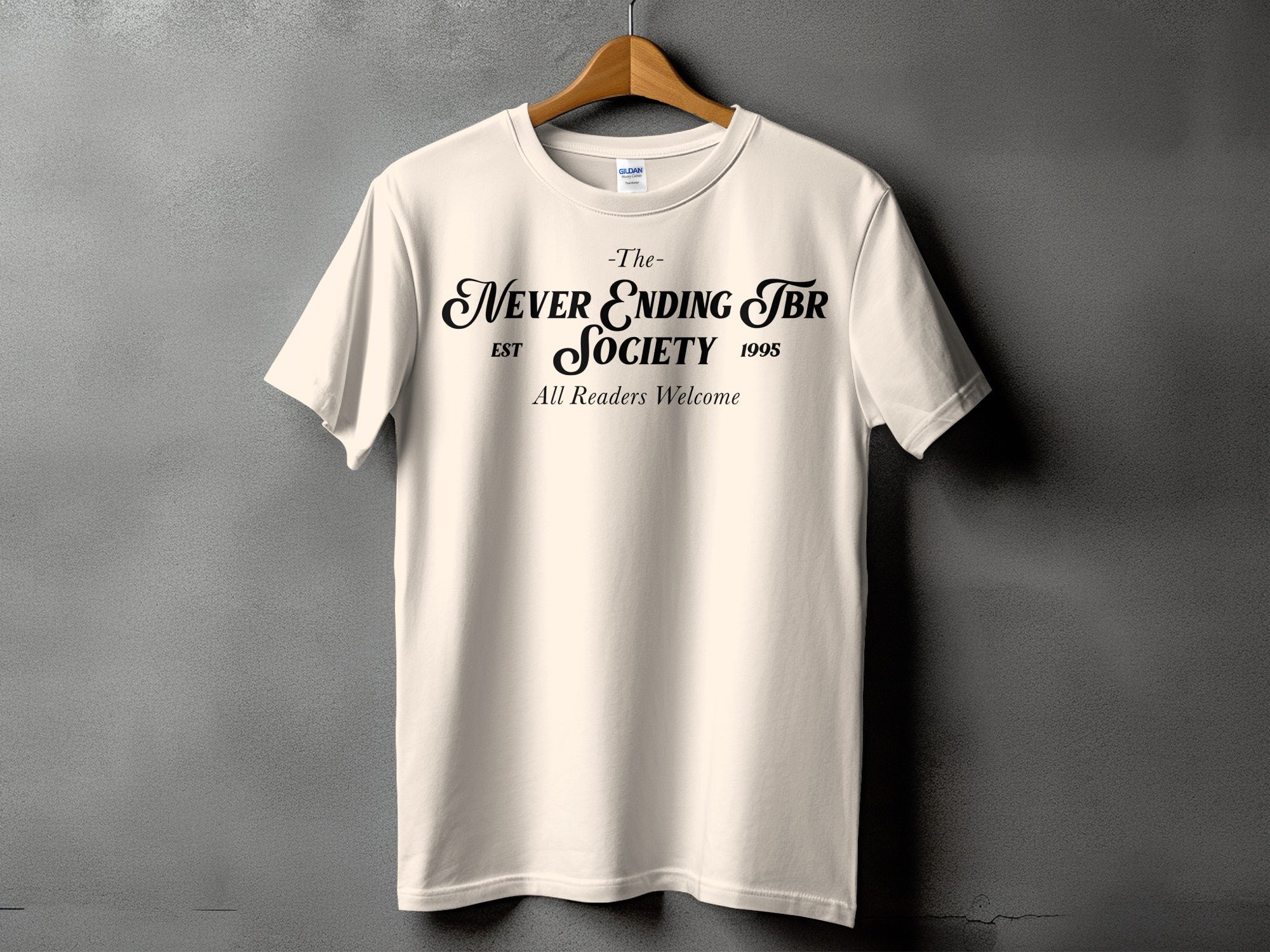 Cream t-shirt with "The Never Ending TBR Society Est 1995 All Readers Welcome" text.