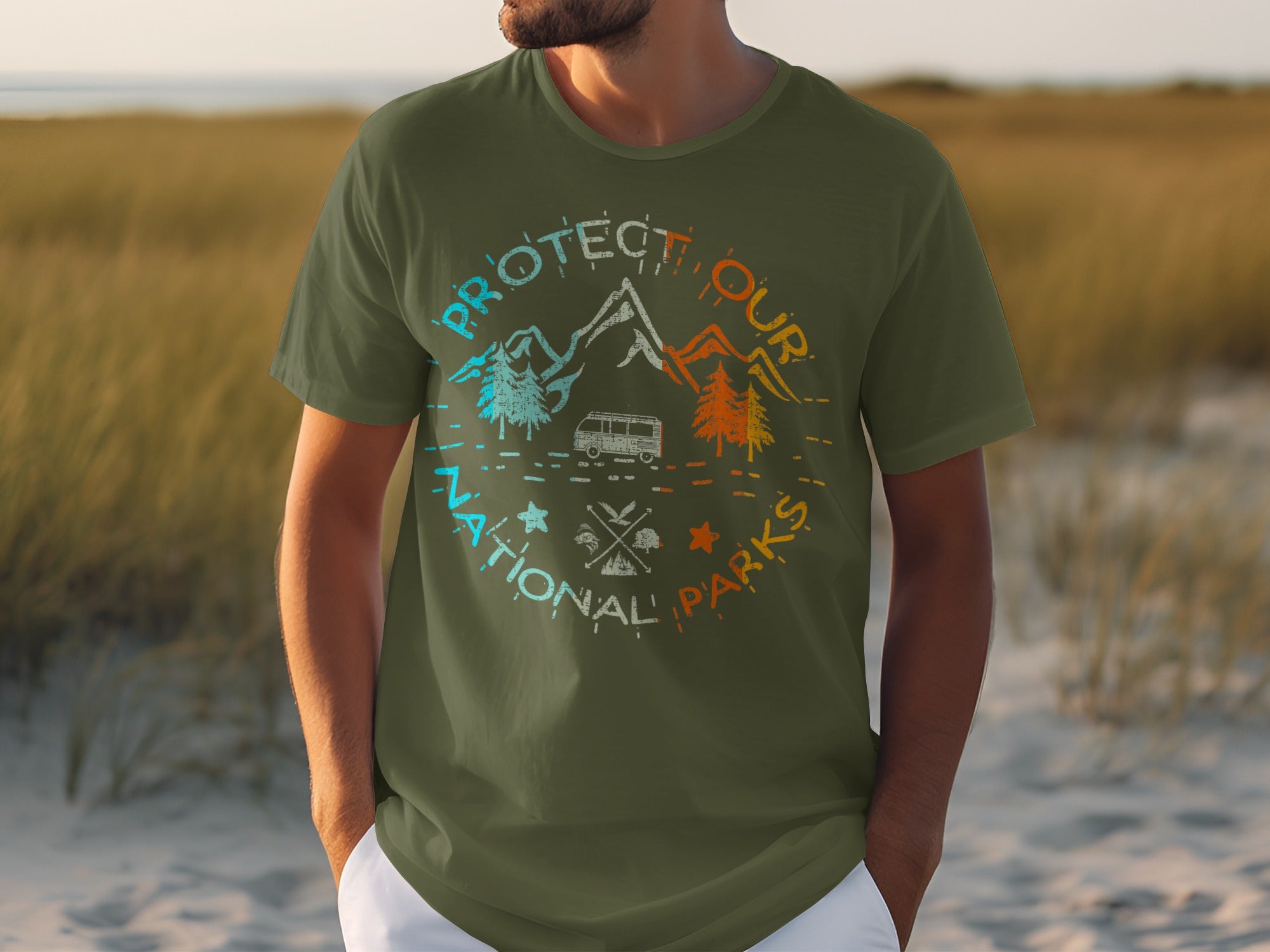 Olive green t-shirt with "Protect Our National Parks" graphic featuring mountains, trees, and a camper van.