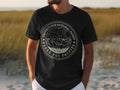 Black t-shirt with a circular design featuring mountains and text.