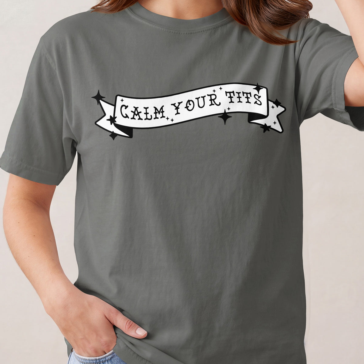 Gray t-shirt with black "Calm Your Tits" text on a banner.