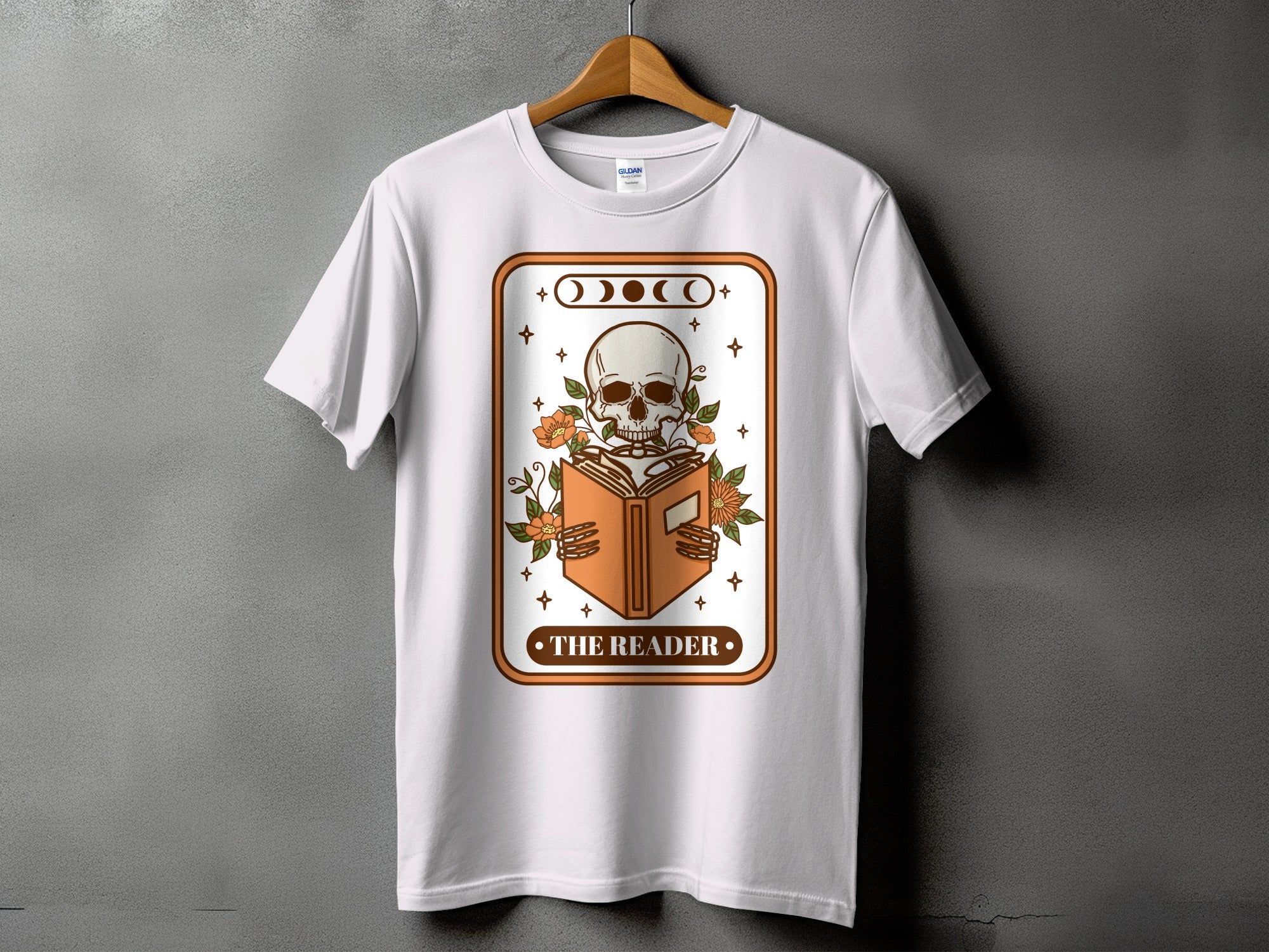 White t-shirt with "The Reader" graphic showing a skeleton reading a book.