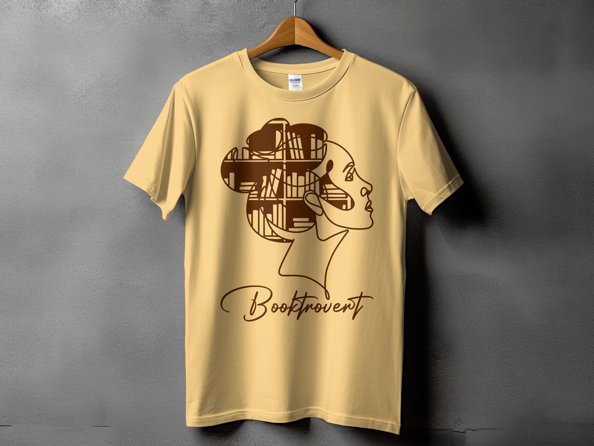 Yellow t-shirt with outline of a woman's profile and the text "Booktrovert."
