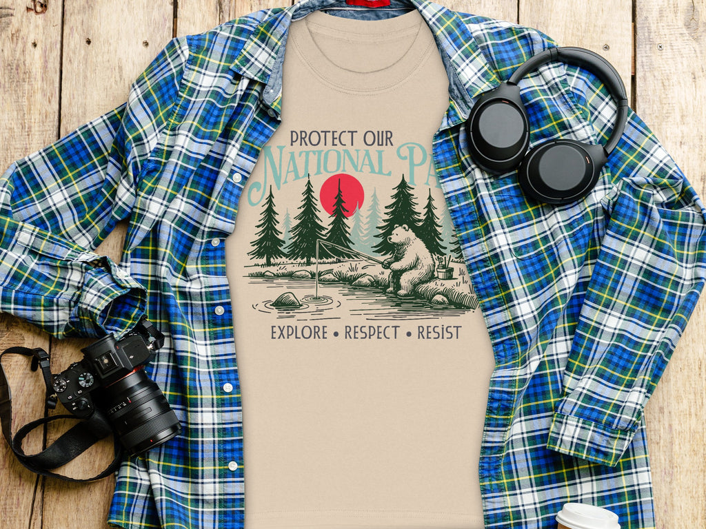 T-shirt with "Protect Our National Parks" text and bear fishing graphic, surrounded by items.